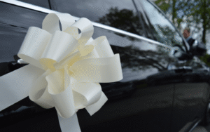 close up of wedding bow decorations on a black merecedes-benz e class wedding car