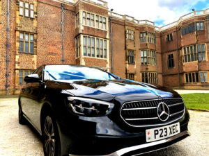 black mercedes-benz wedding car with blue ribbon to match bride and grooms wedding theme at Temple Newsam in Leeds