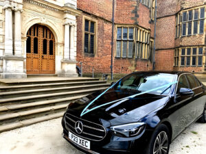 black mercedes-benz wedding car with blue ribbon to match bride and grooms wedding theme at Temple Newsam in Leeds
