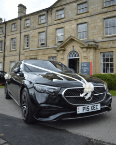 black mercedes-benz e class shot at a low angle decorated for a wedding parked outside of a grade ii listed building in leeds